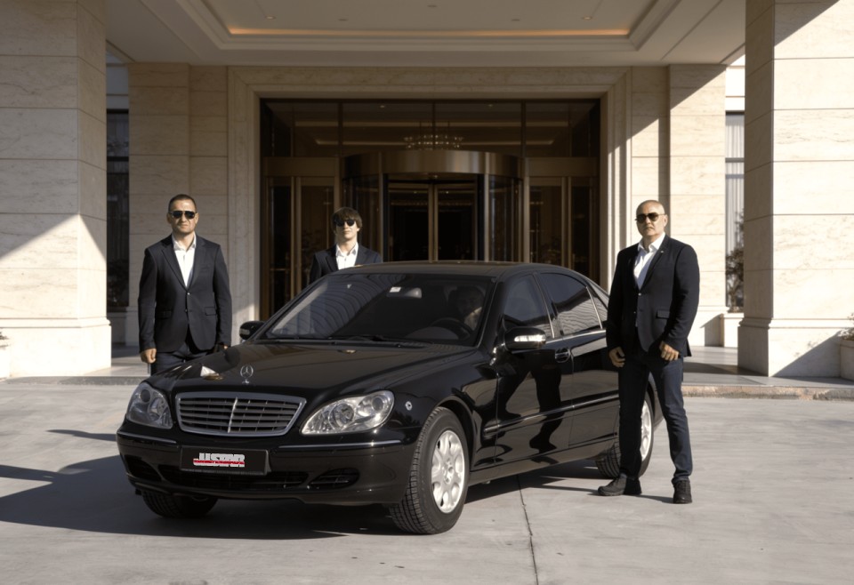 Justar VIP protection team next to a Mercedes car, at the hotel